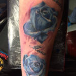 tattoo van twee blauwe rozen met namen erbij