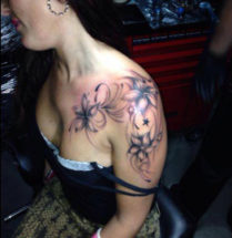 bloemen tatoeage op schouder meid
