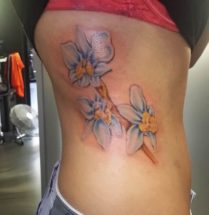 lichtblauwe orchidee tatoeage in de zij.