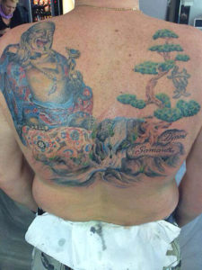tatoeage van een dikke boedha een waterval en een boom op de rug