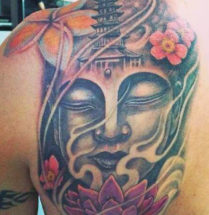 Tattoo van een groot budha hoofd geplaatst op de rug met veel kleurgebruik vooral in de bloemen
