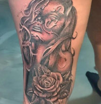 chicano woman tattoo in black, grey and white with long hair and a rose