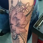 Lotus bloem tatoeage met daaromheen een net
