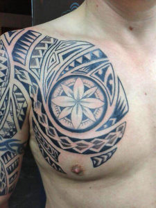 Maori tattoo met een blauw erin op de borst/schouder