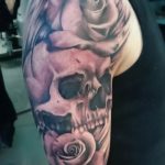 Realistische tattoo van rozen en een skull op bovenarm