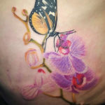 gele vlinder met paarse orchideen tatoeage