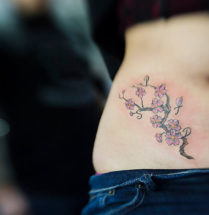 Geplaatst op de buik/zij bloemen tattoo