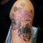 tatoeage van twee zwarte rozen en één roze roos met de tekst jaimee