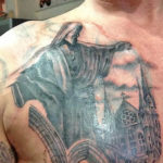 tatoeage van een standbeeld en een kerk geplaatst op de borst door tattoo shop Dutch Ink