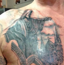tatoeage van een standbeeld en een kerk geplaatst op de borst door tattoo shop Dutch Ink
