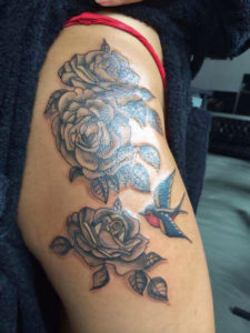 Old school tatoeage van ene zwaluw en enkele grijze rozen geplaatst op de schouder/bovenarm door Dutchink