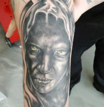 Portret tatoeage van een zwart gezicht met groene ogen die je aankijken