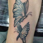 tatoeage op de pols van twee zwarte vlinders waar gebruik is gemaakt van dikke lijnen.