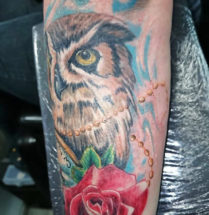 gekleurde uil tatoeage met een roos en veel details