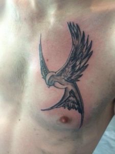 zwarte zwaluw tatoeage op de borst