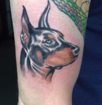 Tattoo van hond met glimmend gezicht.