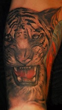 Donkergekleurde tijger tattoo met een rode gloed.
