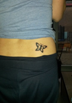kleine vlinder tattoo geplaatst op de zij / onderrug
