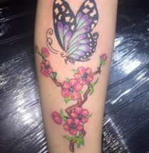 Vlinder met bloemen op onderbeen