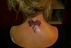 Zwarte strik tattoo geplaatst in de nek