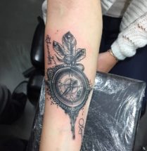Kompas en naam tatoo op onderarm