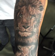 Leeuw met lammetje op onderarm