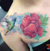 Kolibrie met bloem op schouder/borst